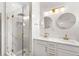Bright bathroom featuring a glass shower and a double sink vanity with gold hardware and marble at 17404 Chateau Pine Way, Clermont, FL 34711