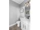 Half bathroom with black and white patterned floors and modern vanity and fixtures at 17404 Chateau Pine Way, Clermont, FL 34711