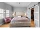 Inviting bedroom features a large bed, cozy seating, and abundant natural light from a window at 17404 Chateau Pine Way, Clermont, FL 34711