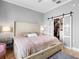 Comfortable bedroom with soft lighting, plush bed, and a closet with sliding frosted doors at 17404 Chateau Pine Way, Clermont, FL 34711