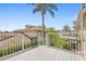 A deck with white railings, a building with light tan siding, and a palm tree at 17404 Chateau Pine Way, Clermont, FL 34711