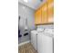 Laundry room featuring washer and dryer with upper cabinets and decorative floor tiles at 17404 Chateau Pine Way, Clermont, FL 34711