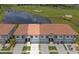 An aerial view of a townhome complex with a red tile roof and a pond at 2041 Greenbriar Ter, Davenport, FL 33837