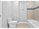 Clean and bright bathroom featuring a modern toilet and a tub-shower combo with decorative stone surround at 2041 Greenbriar Ter, Davenport, FL 33837
