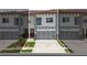 Charming townhouse featuring a garage with glass doors, manicured landscaping, and a stylish modern facade at 2041 Greenbriar Ter, Davenport, FL 33837
