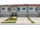 Inviting townhouse showcasing a garage with glass doors, and beautifully maintained landscaping at 2041 Greenbriar Ter, Davenport, FL 33837