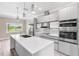 Contemporary kitchen featuring stainless steel appliances, a center island, and views of the outdoors at 2041 Greenbriar Ter, Davenport, FL 33837