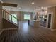 Bright living area with hardwood floors, open staircase, and views of the modern kitchen at 2041 Greenbriar Ter, Davenport, FL 33837