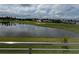 Scenic view of a pond reflecting the sky, surrounded by lush green golf course and houses at 2041 Greenbriar Ter, Davenport, FL 33837