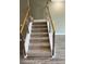 Carpeted staircase with a metal and wood railing, ascending to the next level at 2041 Greenbriar Ter, Davenport, FL 33837
