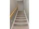 Carpeted staircase with a wooden handrail and white trim at 2041 Greenbriar Ter, Davenport, FL 33837