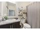Well-lit bathroom features a granite countertop, decorative mirror and shower/tub combination at 2215 Upland Ln, Apopka, FL 32712