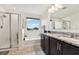 Bright bathroom features a double vanity, granite countertops, bathtub, and separate glass-enclosed shower for a luxurious feel at 2215 Upland Ln, Apopka, FL 32712