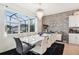 Elegant dining area features a modern chandelier, wall decor, large windows, and sleek dining table at 2215 Upland Ln, Apopka, FL 32712