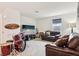 Spacious living room featuring plush seating, modern entertainment center, and drum set at 2215 Upland Ln, Apopka, FL 32712