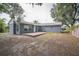 The backyard features a wood deck, a grey exterior, privacy fence and lush foliage at 2307 Freemason St, Lakeland, FL 33801