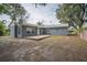 The backyard features a wood deck, a grey exterior and lush foliage at 2307 Freemason St, Lakeland, FL 33801