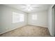 Bright bedroom with ceiling fan, plush carpet, and two windows at 2307 Freemason St, Lakeland, FL 33801