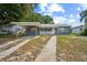 Charming single-story home with a carport and a white picket fence, showcasing its welcoming curb appeal at 2307 Freemason St, Lakeland, FL 33801