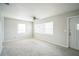 Bright living room with neutral walls, ceiling fan, plush carpet, and natural light from multiple windows at 2307 Freemason St, Lakeland, FL 33801