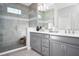 Modern bathroom featuring double sinks, gray cabinets, and a tiled walk-in shower with glass door at 2524 Raghav Trl, Tavares, FL 32778