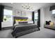 Elegant bedroom with a gray upholstered bed, stylish lighting, neutral decor, and large windows for plenty of natural light at 2524 Raghav Trl, Tavares, FL 32778