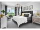 Comfortable bedroom with a gray upholstered bed, modern decor, and a sliding glass door leading to an outdoor seating area at 2524 Raghav Trl, Tavares, FL 32778