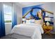Unique bedroom featuring a white bed, playful roller coaster-themed wall art, and a sunny window at 2524 Raghav Trl, Tavares, FL 32778