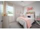 Charming bedroom featuring soft colors, plush bedding, and natural light from the large window at 2530 Raghav Trl, Tavares, FL 32778