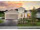 Charming single-story home featuring stone accents, a two-car garage, and lush landscaping at 2530 Raghav Trl, Tavares, FL 32778