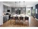 Modern kitchen features an island with seating, stainless steel appliances, and gray cabinetry at 2530 Raghav Trl, Tavares, FL 32778