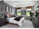 Serene main bedroom featuring neutral tones, tray ceiling, and large windows overlooking the backyard at 2530 Raghav Trl, Tavares, FL 32778