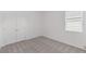 This bedroom features neutral carpet, white walls, a double door closet, and a window that provides natural light at 2533 Raghav Trl, Tavares, FL 32778