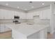 Spacious kitchen featuring an oversized island, stainless steel appliances, and bright white cabinets at 2533 Raghav Trl, Tavares, FL 32778