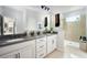 A luxurious bathroom with double sinks, quartz countertops, and a walk-in shower with glass enclosure at 3114 Suraj Cir, Tavares, FL 32778
