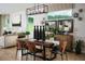A dining room featuring a dark wood table, modern chandelier, and view into the living space at 3114 Suraj Cir, Tavares, FL 32778