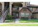 Two-story condo with brick facade, lush landscaping, and convenient staircase access at 320 Forestway Cir # 107, Altamonte Springs, FL 32701