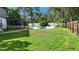 Large, green backyard featuring an in-ground pool, surrounded by a white fence at 359 Westwind Ct, Lake Mary, FL 32746