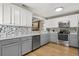 Modern kitchen featuring white and gray cabinets, stainless steel appliances, and a tiled backsplash, a culinary dream at 359 Westwind Ct, Lake Mary, FL 32746