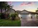Charming single-story home with a brick driveway and a manicured lawn and garden at 3847 Shoreside Dr, Kissimmee, FL 34746