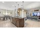 Open-concept kitchen island with bar seating, connected to the living and dining areas at 3847 Shoreside Dr, Kissimmee, FL 34746