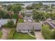 An aerial view shows a single-story home on a large lot with a lake view, a screened-in patio, and mature landscaping at 3902 Brandeis Ave, Orlando, FL 32839