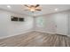 A modern bedroom features wood-look tile flooring, a ceiling fan, and neutral paint for a serene and inviting atmosphere at 3902 Brandeis Ave, Orlando, FL 32839