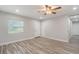 A modern bedroom features wood-look tile flooring, a ceiling fan, and neutral paint for a serene and inviting atmosphere at 3902 Brandeis Ave, Orlando, FL 32839