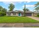 Charming single-story home featuring a well-manicured lawn, a blue front door, and an attached two-car garage at 3902 Brandeis Ave, Orlando, FL 32839