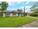 Charming single-story home featuring a well-manicured lawn, a blue front door, and an attached two-car garage at 3902 Brandeis Ave, Orlando, FL 32839