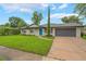 Charming single-story home featuring a well-manicured lawn, a blue front door, and a gray two-car garage at 3902 Brandeis Ave, Orlando, FL 32839