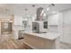 Bright kitchen with stainless appliances, island cooktop, quartz counters, and sleek hood at 3902 Brandeis Ave, Orlando, FL 32839