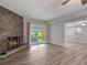 Living area with wood-look tile floors, a stone fireplace, and sliding glass doors to the yard at 3902 Brandeis Ave, Orlando, FL 32839