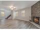 Open living space with a brick fireplace and wood-look tile floors plus staircase access at 3902 Brandeis Ave, Orlando, FL 32839